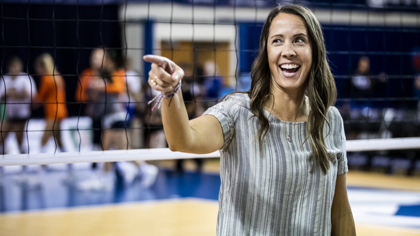Head coach Heather Olmstead points to the crowd after earning 200th-career win, the fastest in NCAA DI women's volleyball history to do so, at 25 games