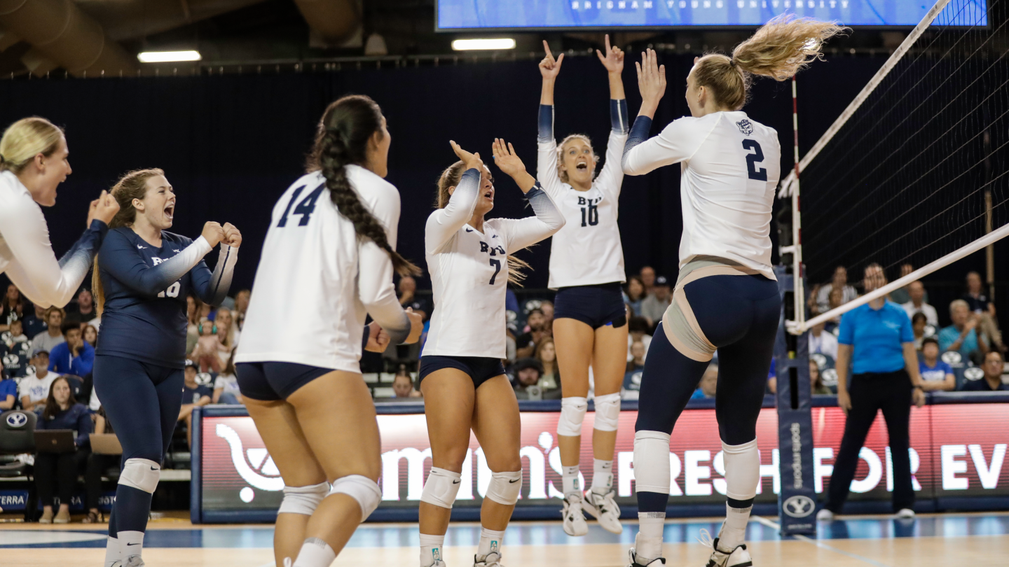 Heather Gneiting celebrates with her team after a kill during a game against LMU.